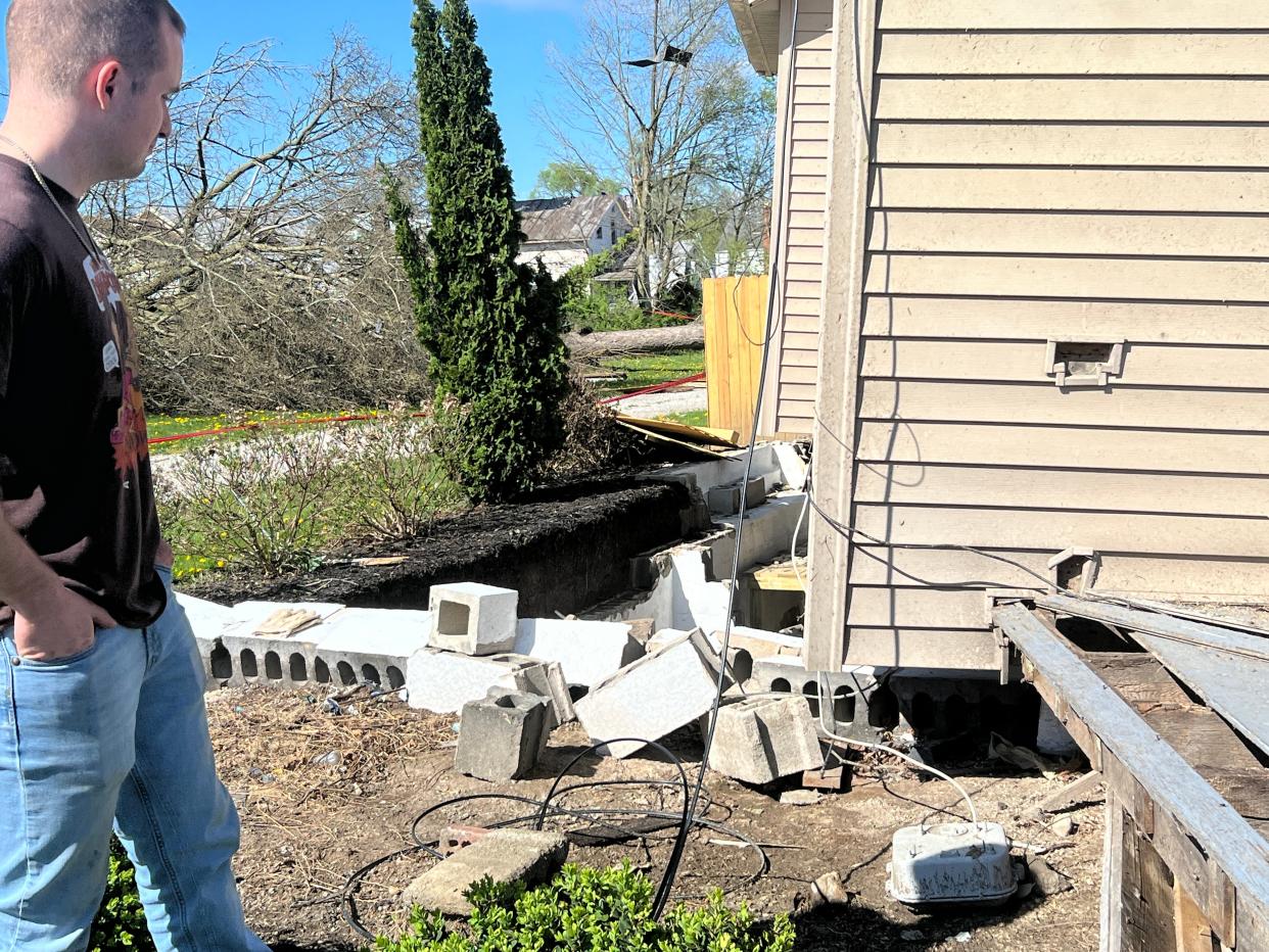 Eric Thomas assesses the damage to his two-story Kaler Avenue home after a reported tornado hit the city of Bucyrus on Wednesday. His house was lifted off of its foundation, and is unlivable, he said.