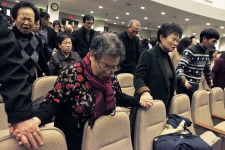 Participants hold hands together as they pray for Canadian pastor Hyeon Soo Lim who is being held in North Korea during a joint multi-cultural prayer meeting at Light Korean Presbyterian Church in Toronto, December 20, 2015. REUTERS/Hyungwon Kang