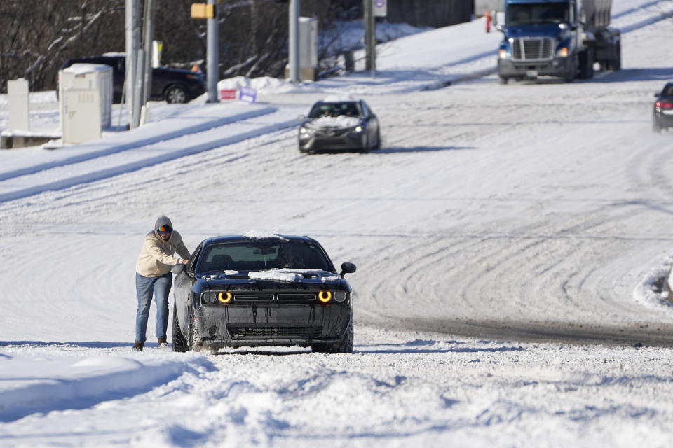 Un automovilista empuja su vehículo en un camino nevado el martes 16 de enero de 2024, en Nashville, Tennessee. (AP Foto/George Walker IV)