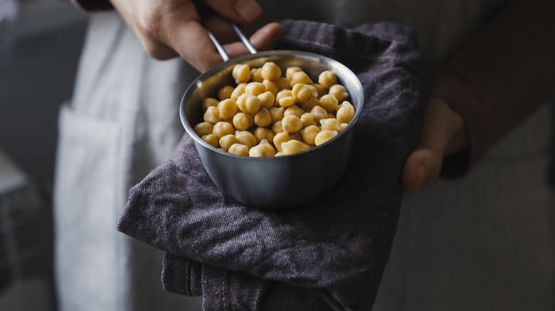 person holding cup of chickpeas