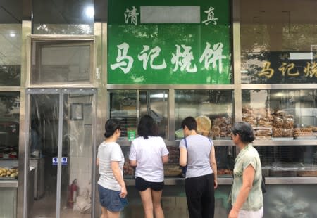 The Arabic script on the signboard of a halal food store is seen covered, at Niujie area in Beijing