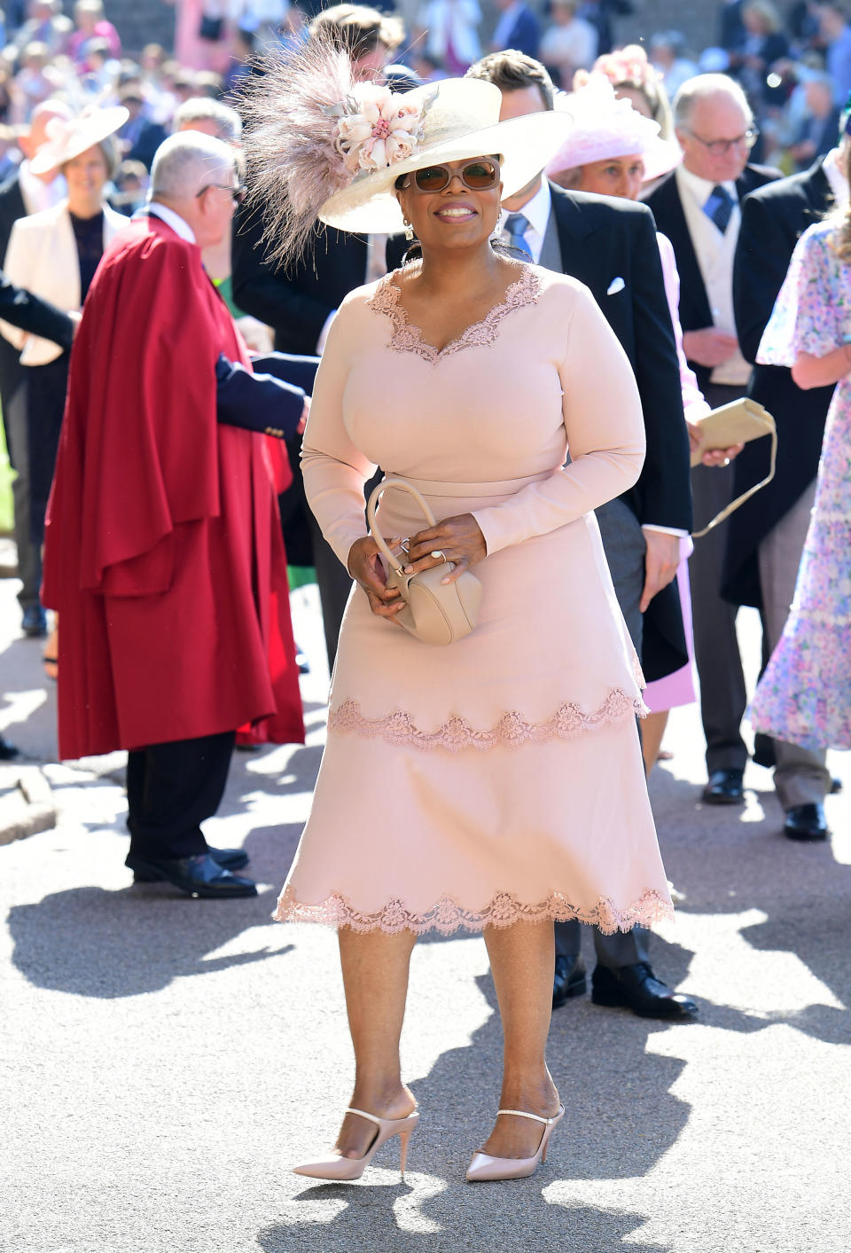 <p>Wearing pastel pink and a Philip Treacy hat, Oprah couldn’t keep the smile off her face as she headed to St George’s Chapel. Photo: Getty </p>