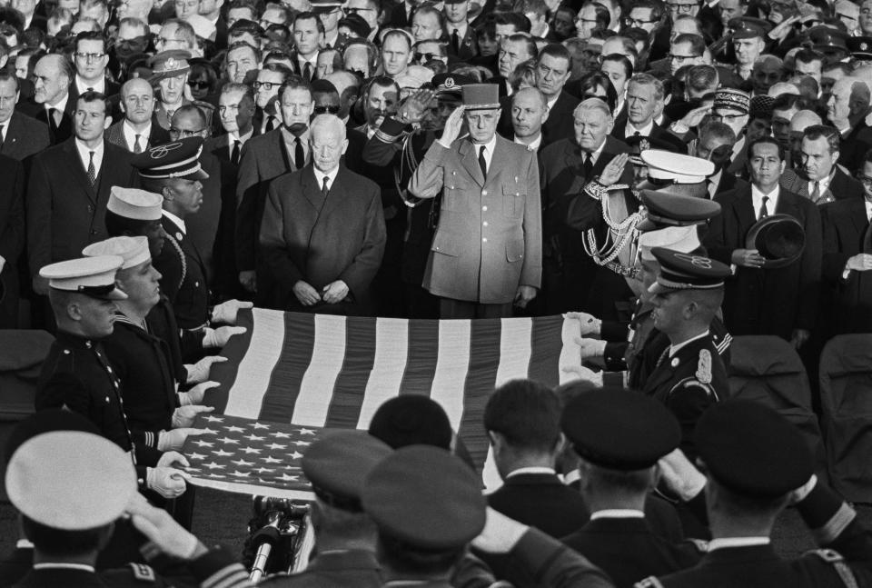 German President Heinrich Luebke (L), French President General Charles de Gaulle (C), Germany's Chancellor Ludwig Erhard (3rd L), French Premier Maurice Couve de Murville (4th L), President of the Philippines, Diosdado Macapagal (R) and officials and foreign dignitaries pay their last respects in front of the coffin of late US President John Fitzgerald Kennedy, on November 25, 1963 in Arlington cemetery, during his state funeral, as honor guard pallbearers lift the casket flag.