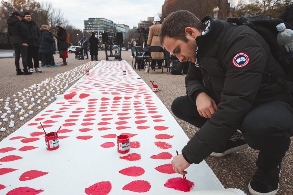 Participants paint a blood teardrop shape during a vigil with progressive lawmakers and activists currently on hunger strike outside the White House to demand that President Joe Biden call for a permanent ceasefire in Gaza.
