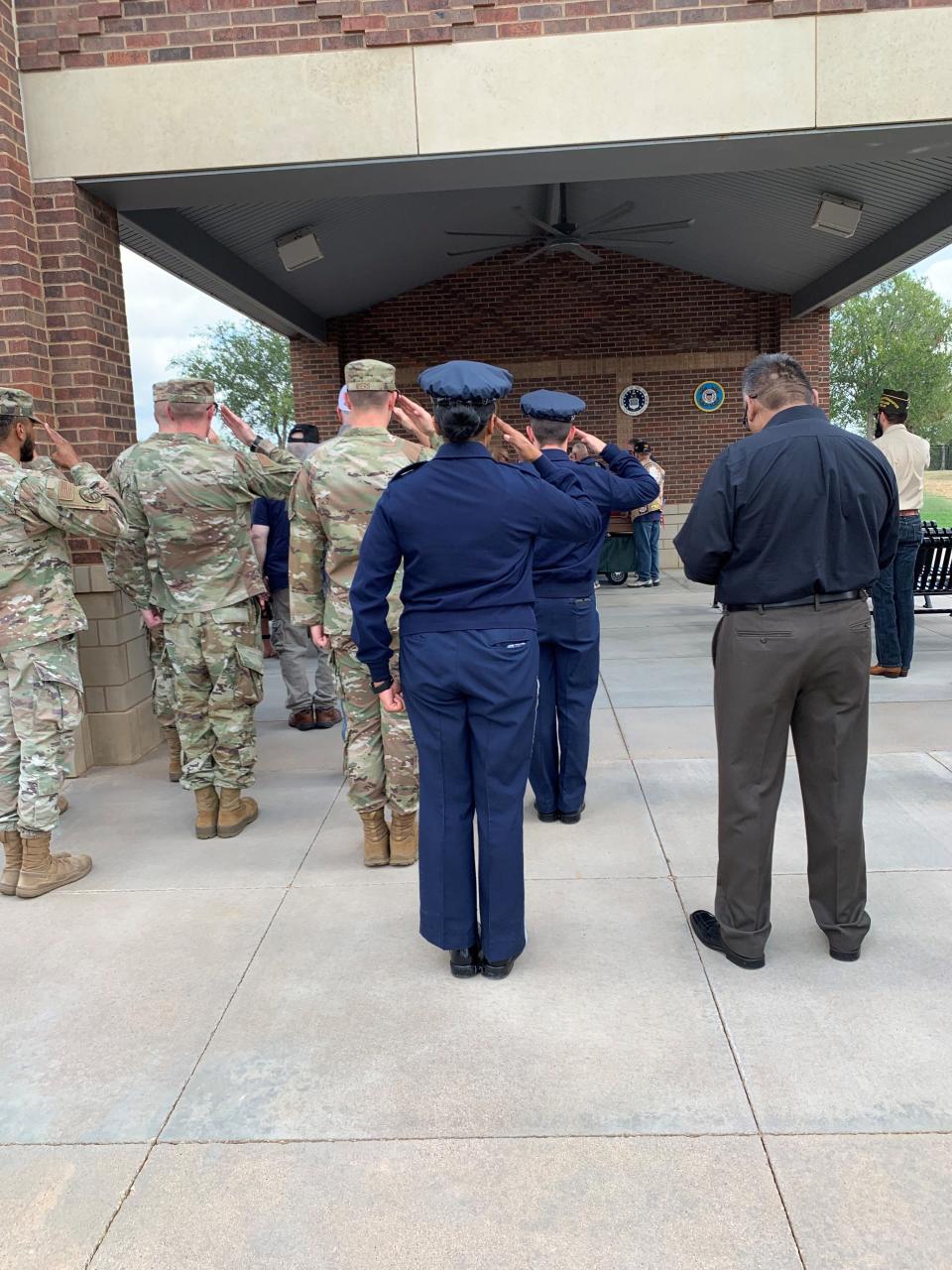 Members of the active-duty armed forces salute the unaccompanied veteran, Bob G. Wood, as his casket enters a pavilion inside the Texas State Veterans Cemetery at Abilene on July 29, 2024.