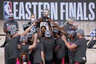 The Miami Heat celebrate their NBA conference final playoff basketball game win over the Boston Celtics with the Eastern Final trophy Sunday, Sept. 27, 2020, in Lake Buena Vista, Fla. (AP Photo/Mark J. Terrill)