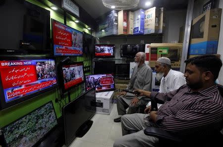 Men look at television screens displaying the coverage of Pakistan's Supreme Court’s decision on a case related to Panama Papers leaks, at an electronics shop in Karachi, Pakistan April 20, 2017. REUTERS/Akhtar Soomro