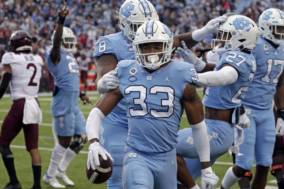 FILE - North Carolina linebacker Cedric Gray (33) celebrates with teammates after he intercepted a pass against Virginia Tech during the first half of an NCAA college football game in Chapel Hill, N.C., Oct. 1, 2022. North Carolina opens the season against South Carolina on Sept. 2, 2023. (AP Photo/Chris Seward, File)