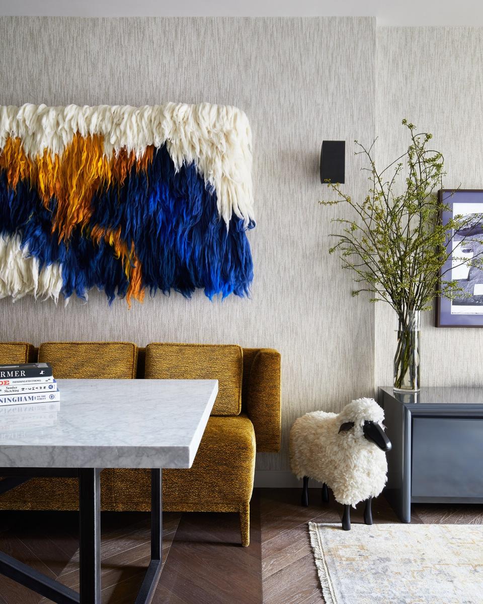 The dining room features a bespoke piece over the KGBL banquette from artist Meghan Shimek. “We commissioned her to design a version for that space with the colors that we have featured in the New York apartment,” Mikita says. The dining room table is from RH, and the sheep is vintage (and named Timothée Chalamet by Mikita).