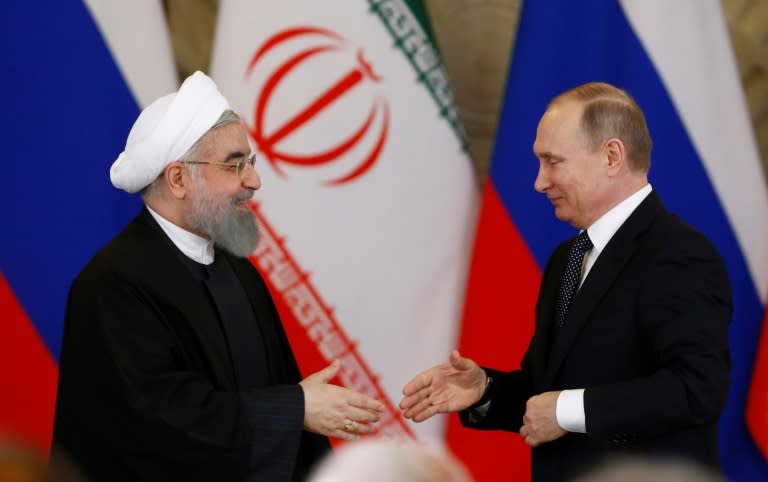 Russian President Vladimir Putin (R) shakes hands with his Iranian counterpart Hassan Rouhani during a joint press conference following their meeting at the Kremlin in Moscow on March 28, 2017