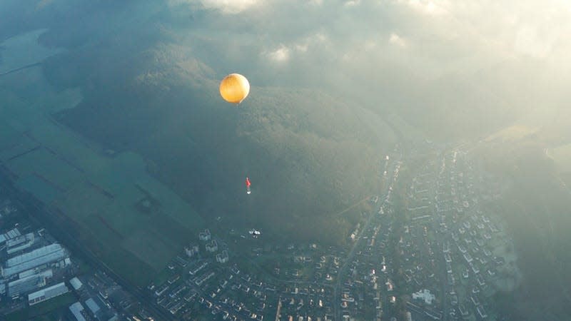 Stock photo of weather balloon floating above land