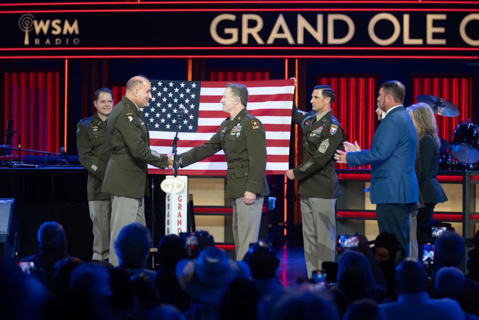 Staff Sgt. Craig Morgan joins General Poppas, commander of the U.S. Army Forces Command, after enlisting and being sworn into the U.S. Army Reserve during the live Grand Ole Opry show on Saturday, July 29.