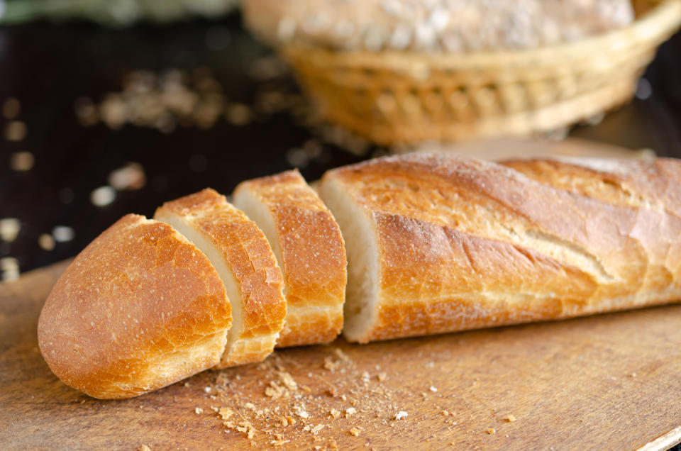 Sliced freshly baked bread on on cutting board. Kitchen utensils, organic food