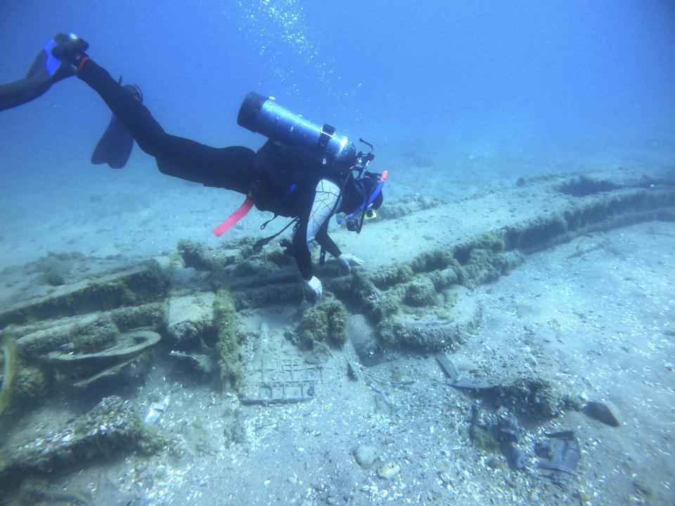 This Aug. 15, 2021 photo, videographer Nicholas Lusardi investigates the wing of a downed P-39 Airacobra in Lake Huron, Mich. The plane that crashed during a training mission in April 1944, killing Lt. Frank Moody, a Tuskegee airman. Archaeologists are racing to document Great Lakes shipwrecks and downed planes before quagga mussels disintegrate them. (Wayne Lusardi via AP)
