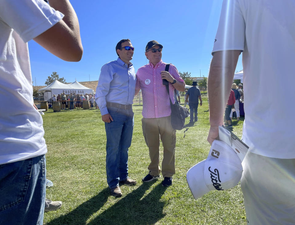 Republican Nevada Senate candidate Adam Laxalt, center left, takes pictures with supporters at the seventh annual Basque Fry at the Corley Ranch on Saturday, Aug. 13, 2022, outside Gardnerville, Nev. (AP Photo/Gabe Stern)