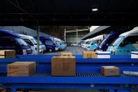 Parcels are conveyed as trucks for delivery are parked at a CJ Logistics distribution center in Gwangju