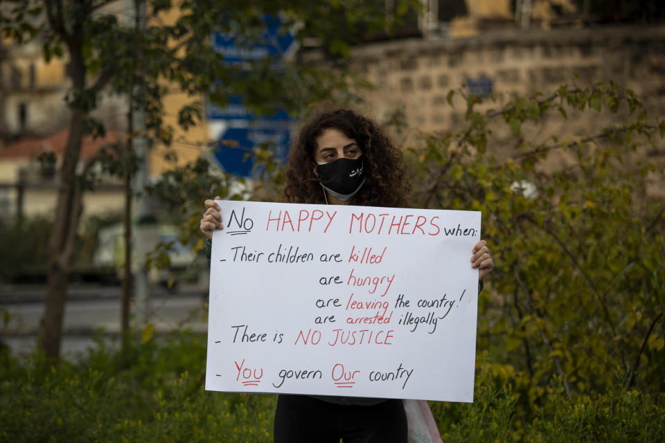 A protester holds a placard as she participates in a march against the political leadership they blame for the economic, financial crisis and 4 Aug. Beirut blast, in Beirut, Lebanon, Saturday, March 20, 2021. (AP Photo/Hassan Ammar)