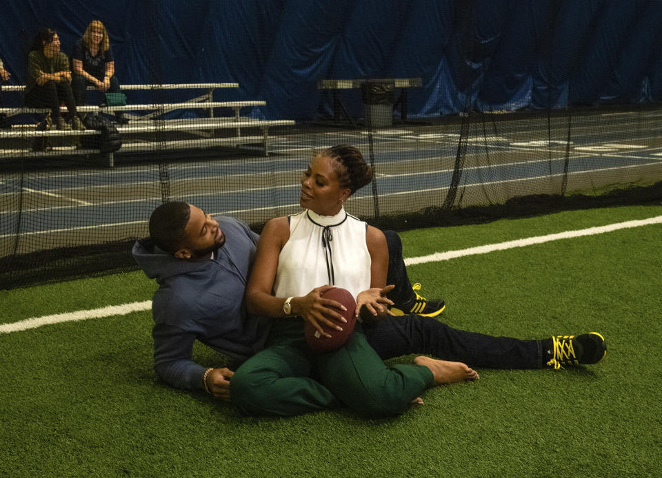 This image released by OWN shows Devale Ellis and Eva Marcille in a scene from “A Christmas Fumble,” airing Dec. 10. (OWN via AP)