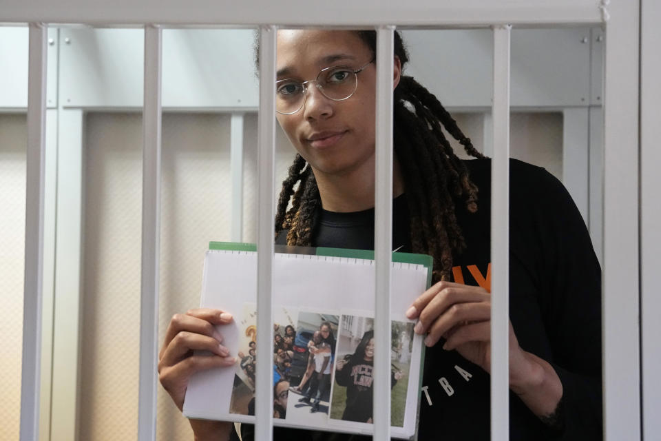 WNBA star and two-time Olympic gold medalist Brittney Griner holds images standing in a cage at a court room prior to a hearing, in Khimki just outside Moscow, Russia, Wednesday, July 27, 2022. American basketball star Brittney Griner returned Wednesday to a Russian courtroom for her drawn-out trial on drug charges that could bring her 10 years in prison of convicted. (AP Photo/Alexander Zemlianichenko, Pool)