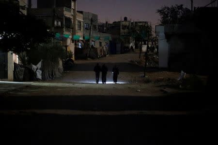 Palestinians walk on a road during a power cut in Beit Lahiya in the northern Gaza Strip. REUTERS/Mohammed Salem