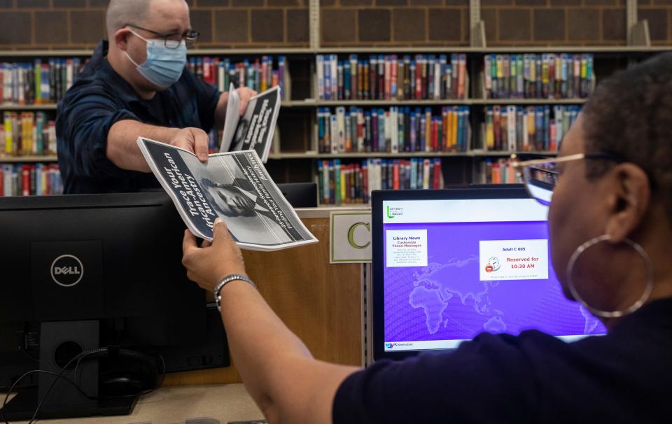 Matthew Scheich, a technical training associate, hands out packets during a genealogy class inside the Detroit Public Library Redford Branch in Detroit on Nov. 21, 2023.
