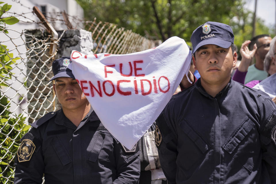 Relatives of people missing during the last military dictatorship hold a banner reading in Spanish “It was a genocide” at the arrival of the vice-presidential candidate of the Liberty Advances coalition, Victoria Villarruel, to vote in the presidential runoff election in Buenos Aires, Argentina, Sunday, Nov. 19, 2023. (AP Photo/Rodrigo Abd)