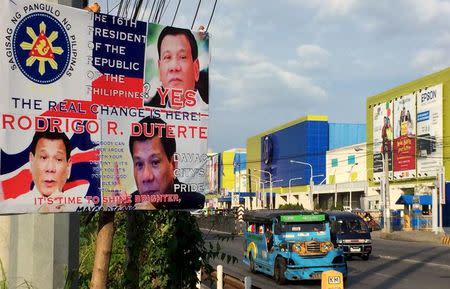 A jeepney drives past an election poster of Philippine presidential candidate Rodrigo Duterte in Davao city, Philippines April 22, 2016. REUTERS/Martin Petty