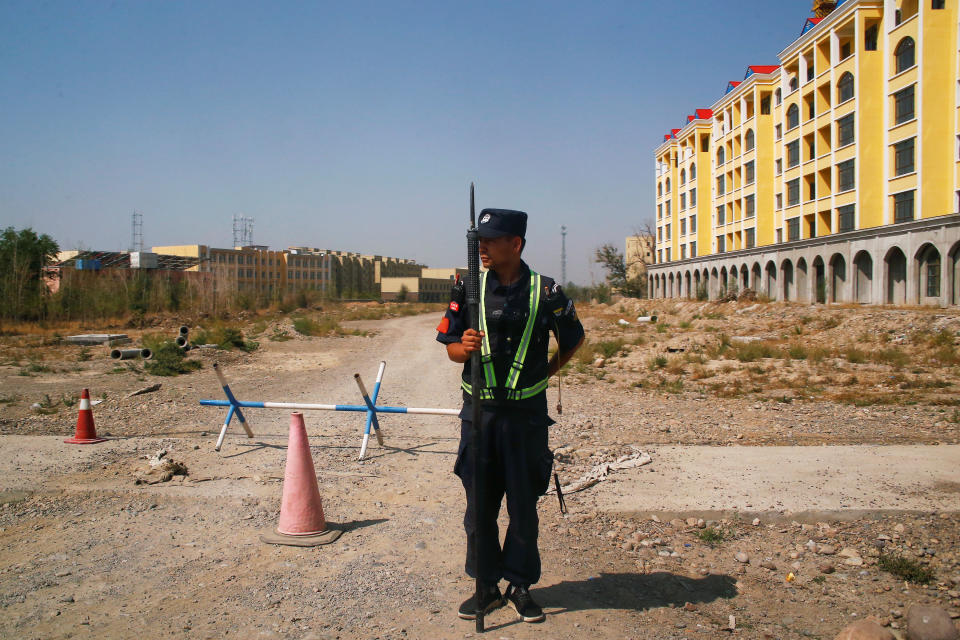 A Chinese police officer takes his position by the road near what is officially called a vocational education centre in Yining in Xinjiang Uighur Autonomous Region, China September 4, 2018. Picture taken September 4, 2018. To match Special Report MUSLIMS-CAMPS/CHINA REUTERS/Thomas Peter