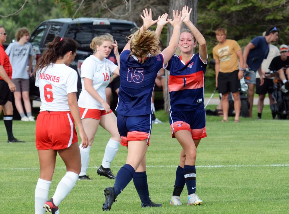 Boyne City's Braylin Noble (15) congratulates teammate Elly Day after Day scored in the first half of Tuesday's Division 3 district game in Boyne Falls against Benzie Central. It was a four goal, two assist day for Day.