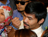 Philippine boxing star and Senator Manny Pacquiao shows a clenched fist as he poses with supporters, after he was declared by elections officials as one of the 12 new members of the upper house of Congress in Manila, Philippines May 19, 2016. REUTERS/Erik De Castro