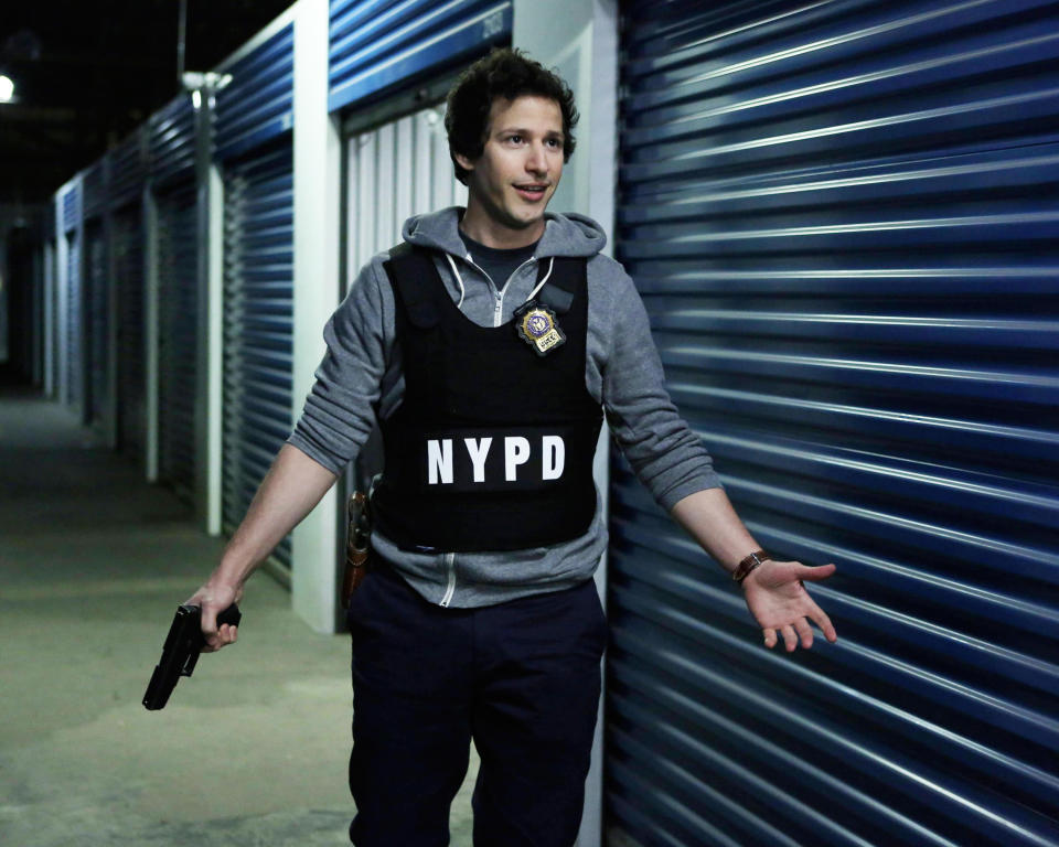 man in an NYPD vest and holding a gun