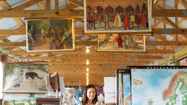 a woman looking at vintage maps at the blue hills tent in round top, texas