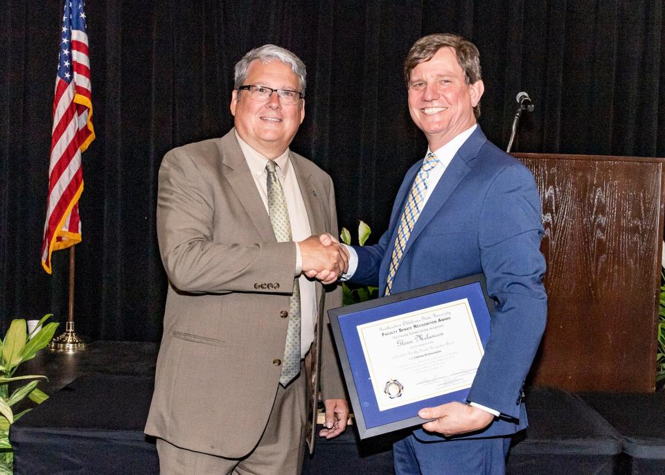 Dr. Glenn Melancon received the Faculty Senate Lifetime Achievement Award and is congratulated by Southeastern president Thomas Newsom.