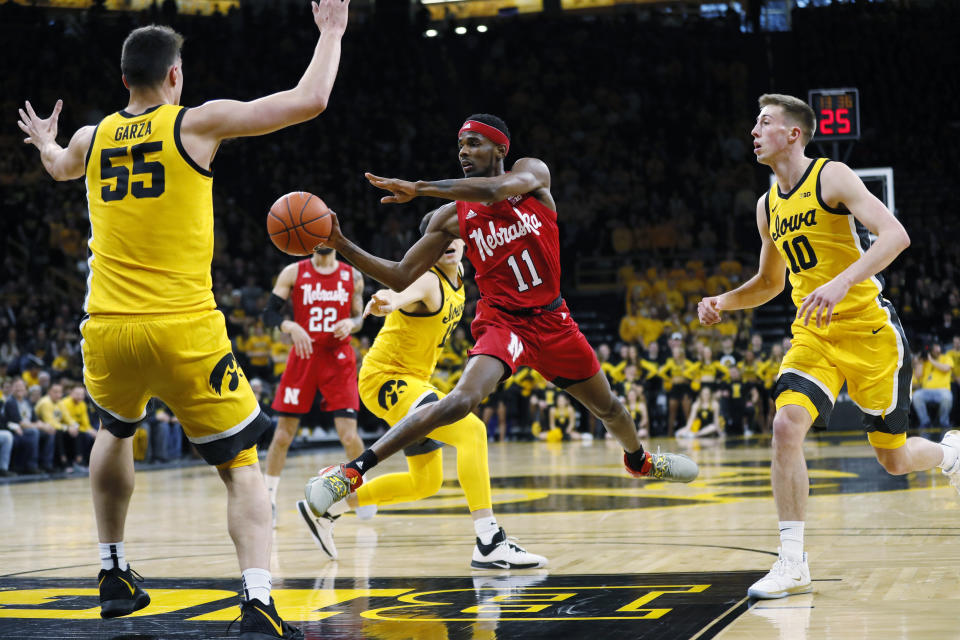 Nebraska guard Dachon Burke Jr. (11) drives to the basket between Iowa's Luka Garza (55) and Joe Wieskamp (10 during the first half of an NCAA college basketball game, Saturday, Feb. 8, 2020, in Iowa City, Iowa. (AP Photo/Charlie Neibergall)