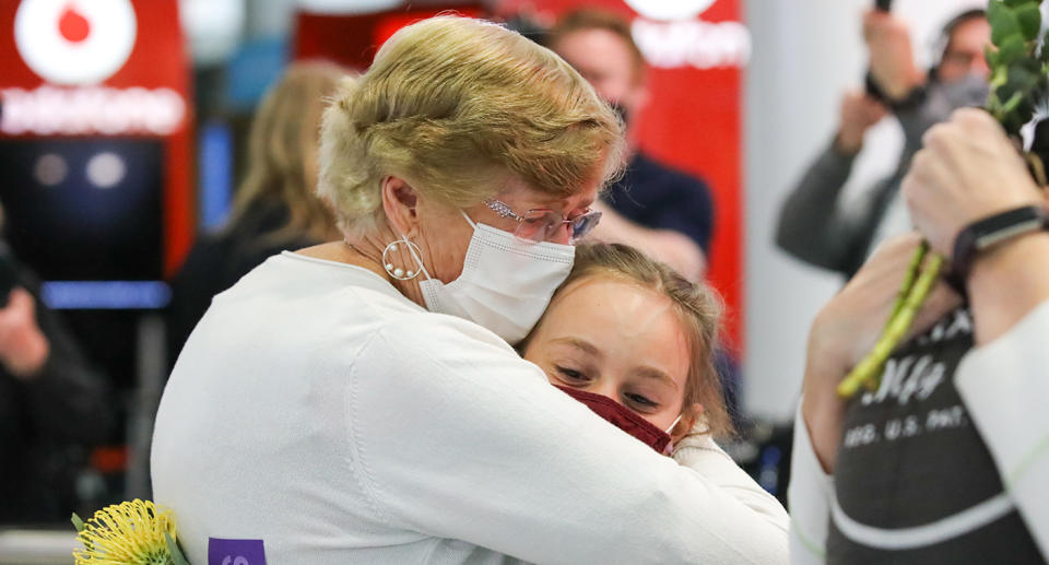 A woman and a young girl hugging at the airport as quarantine is scrapped for international arrivals in NSW.