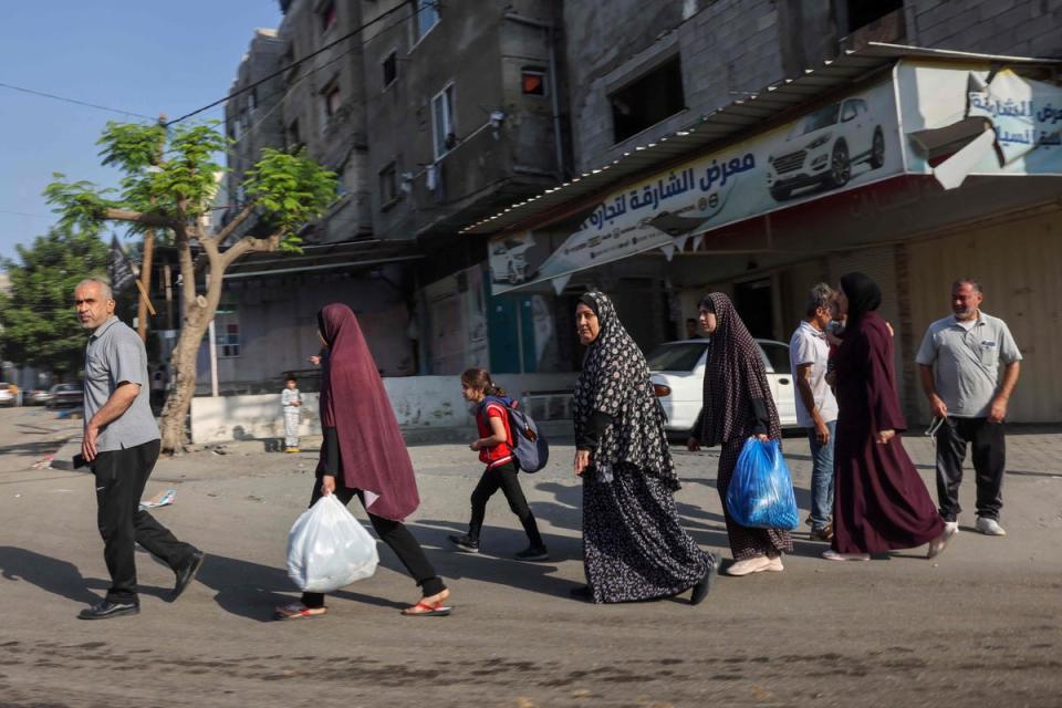 Palestinians carrying their belongings flee to safer areas in Gaza City after Israeli air strikes, on October 13, 2023. (AFP via Getty Images)