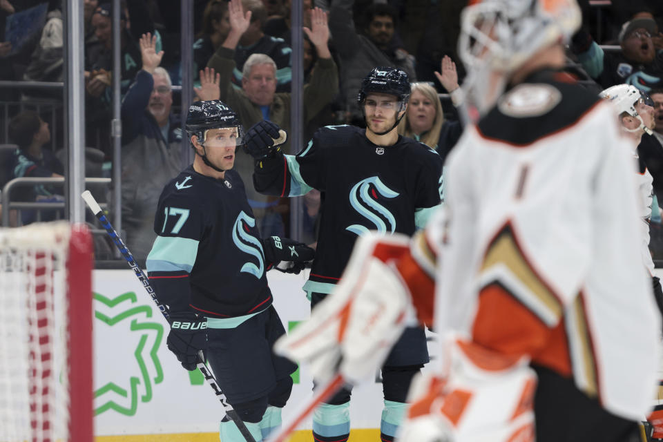 Seattle Kraken center Jaden Schwartz (17) and center Alex Wennberg (21) celebrate after Schwartz's goal as Anaheim Ducks goaltender Lukas Dostal (1) looks on during the first period of an NHL hockey game Thursday, March 30, 2023, in Seattle. (AP Photo/Jason Redmond)