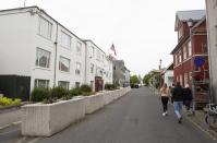 People walk past the US embassy in Reykjavik, Iceland Saturday Aug. 1, 2020. In Iceland, a nation so safe that its president runs errands on a bicycle, U.S. Ambassador Jeffery Ross Gunter has left locals aghast with his request to hire armed bodyguards. He's also enraged lawmakers by casually and groundlessly hitching Iceland to President Donald Trump's controversial "China virus” label for the coronavirus. (AP Photo/Árni Torfason)