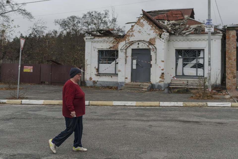 A woman passes an apartment building destroyed by fighting, in the village of Moshun, outside Kyiv, Ukraine, Friday, Nov. 4, 2022. Moschun was hard-hit at the start of the war, approximately 37 people were killed, — among a population of about 1,000 — and 160 homes were completely destroyed, say residents. The town was occupied by Russian troops for nearly six weeks. (AP Photo/Andrew Kravchenko)