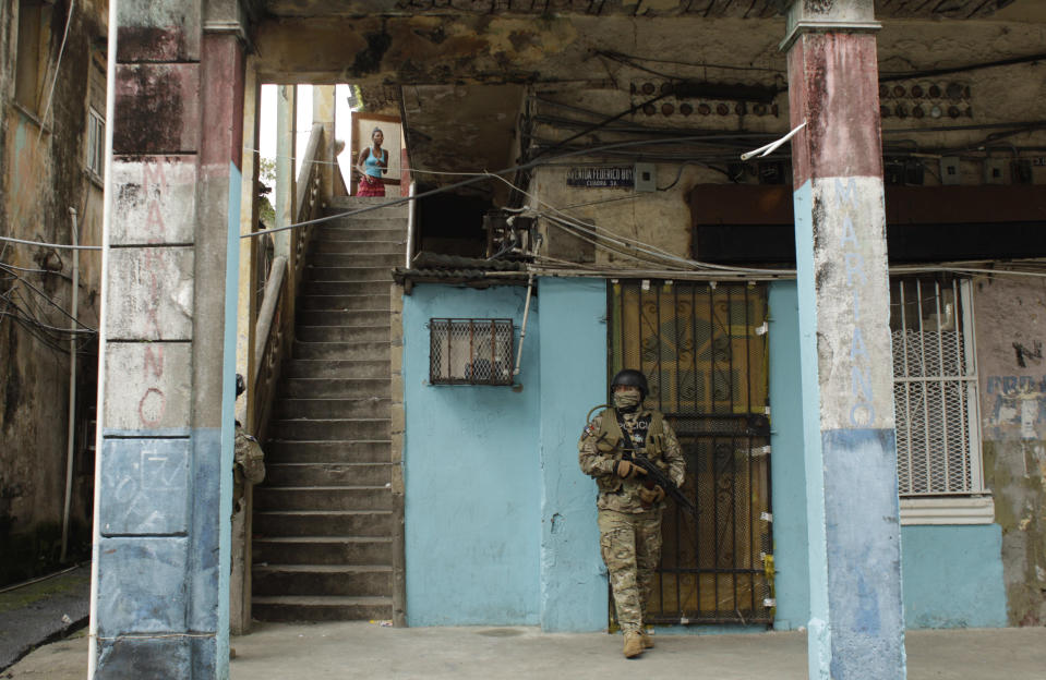 A masked police officer stands guard in a residential area of Colon, Panama, Saturday, Oct. 20, 2012. Police began patrolling Colon after violent protests Friday over a new law allowing the sale of state-owned land to private companies already leasing land there to handle the import and export of goods in the duty-free zone next to the Panama Canal. Protesters want the government to instead raise the rent and invest the money in Colon, a poor and violent city. (AP Photo/Arnulfo Franco)