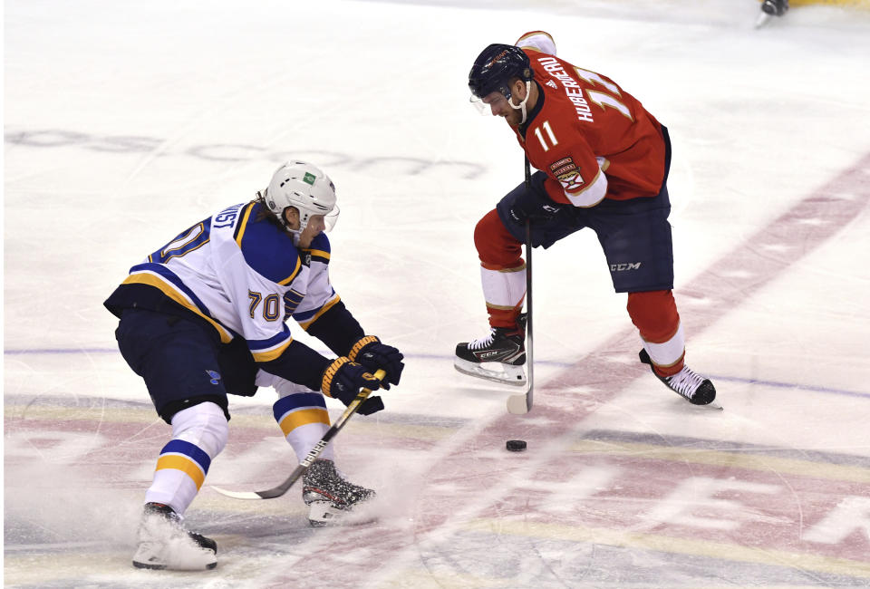 Florida Panthers left wing Jonathan Huberdeau (11) skates around St. Louis Blues left wing Brandon Saad (20) during the first period of an NHL hockey game Saturday, Dec. 4, 2021, in Sunrise, Fla. (AP Photo/Jim Rassol)