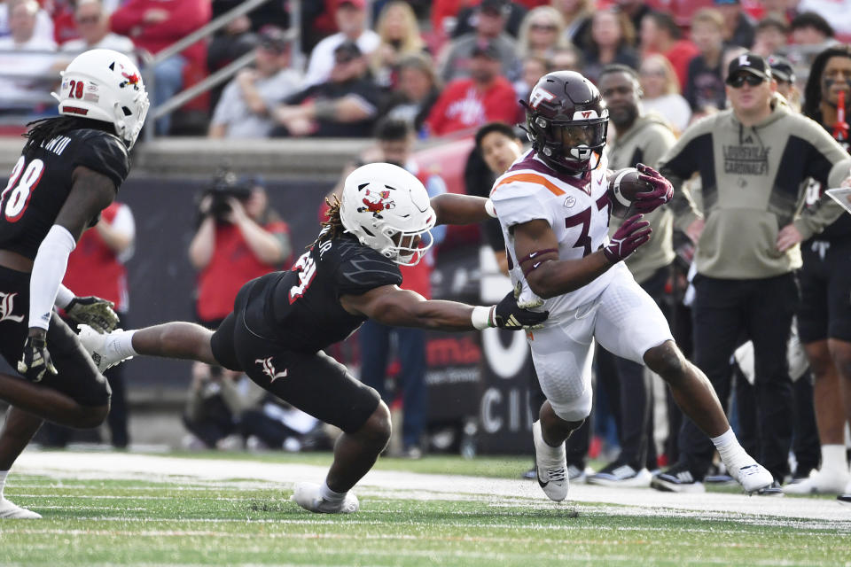 Louisville linebacker TJ Quinn (34) attempts to tackle Virginia Tech running back Bhayshul Tuten (33) during the first half of an NCAA college football game in Louisville, Ky., Saturday, Nov. 4, 2023. Louisville won 34-3. (AP Photo/Timothy D. Easley)