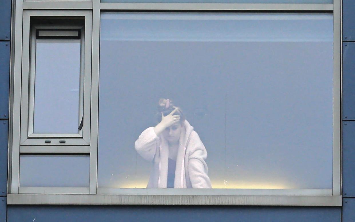 A student is seen at the window in a halls of residence for students in Newcastle-upon-Tyne -  LINDSEY PARNABY / AFP