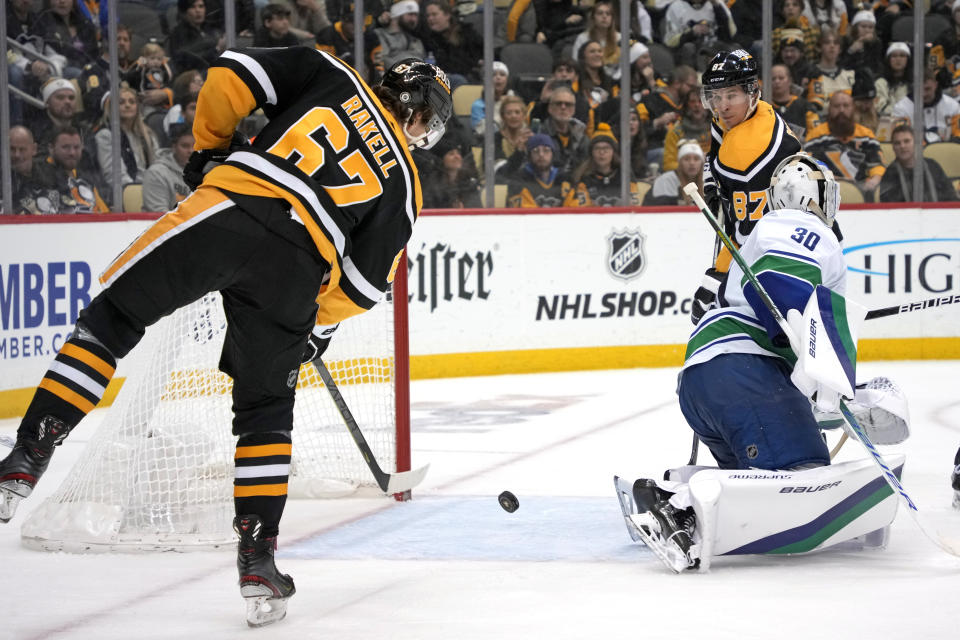 Pittsburgh Penguins' Rickard Rakell (67) put a shot behind Vancouver Canucks goaltender Spencer Martin (30) for a goal during the second period of an NHL hockey game in Pittsburgh, Tuesday, Jan. 10, 2023. (AP Photo/Gene J. Puskar)