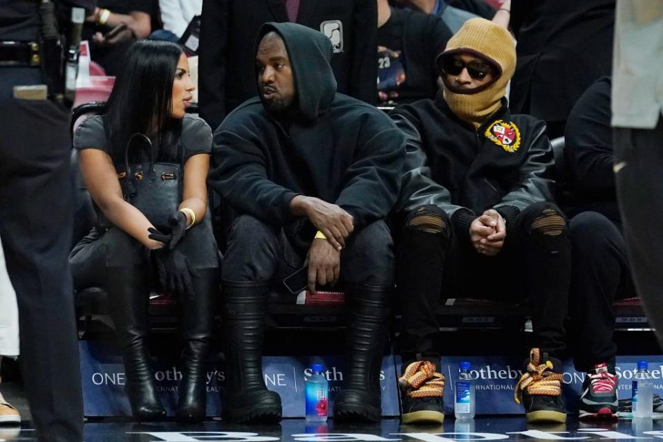 Kanye West and Chaney Jones sit courtside with Future (R) at the Miami Heat and the Minnesota Timberwolves basketball game in Miami on March 12, 2022. - Credit: AP