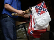 FILE - In this July 9, 2015, file photo, a cemetery caretaker holds a bundle of banners that includes the second national flag of the Confederacy, the "Stainless Banner," in Elmira, N.Y. While the Confederate battle flag with its blue X design is the best known flag of the Confederacy, the nation had multiple other flags. (AP Photo/Heather Ainsworth, File)