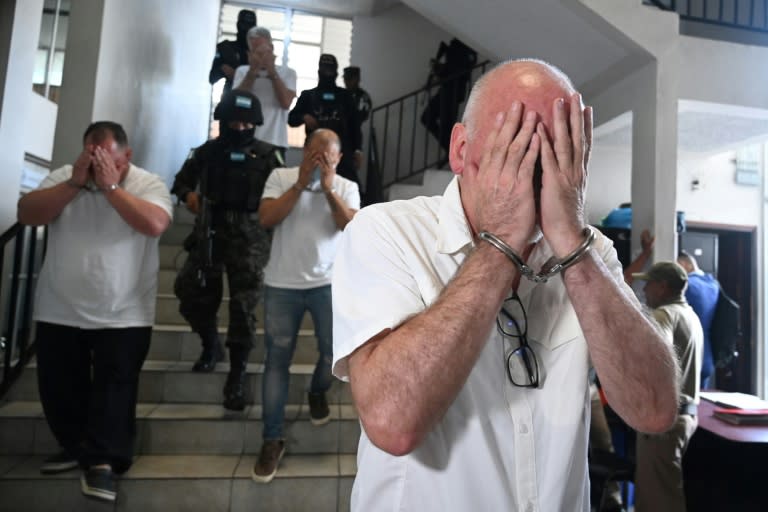 US citizens Harold Joseph Green (R), Wiliam James Murdock (L) and Gary Lee Johnston (Ctr), cover their faces near a court in Tegucigalpa (Orlando SIERRA)