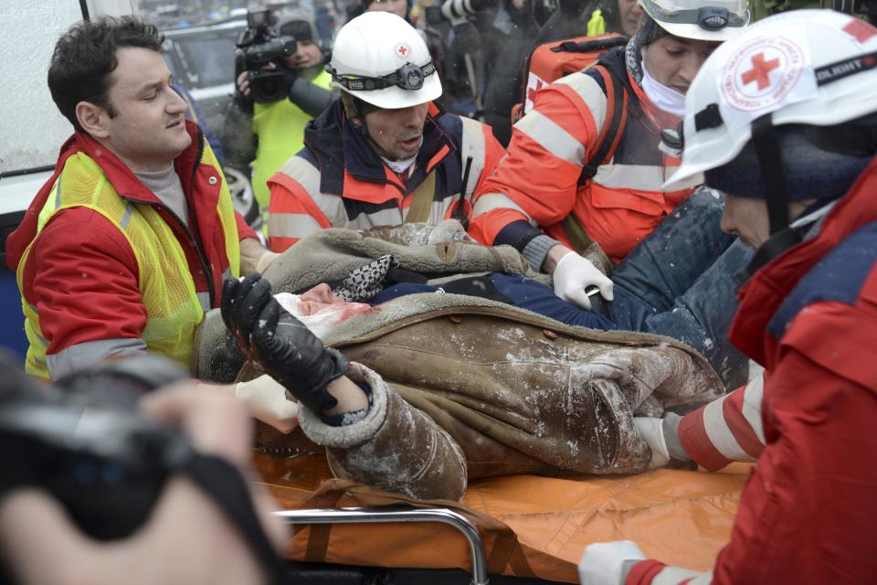 Medical personnel transport a man who was injured during clashes with riot police in Kiev