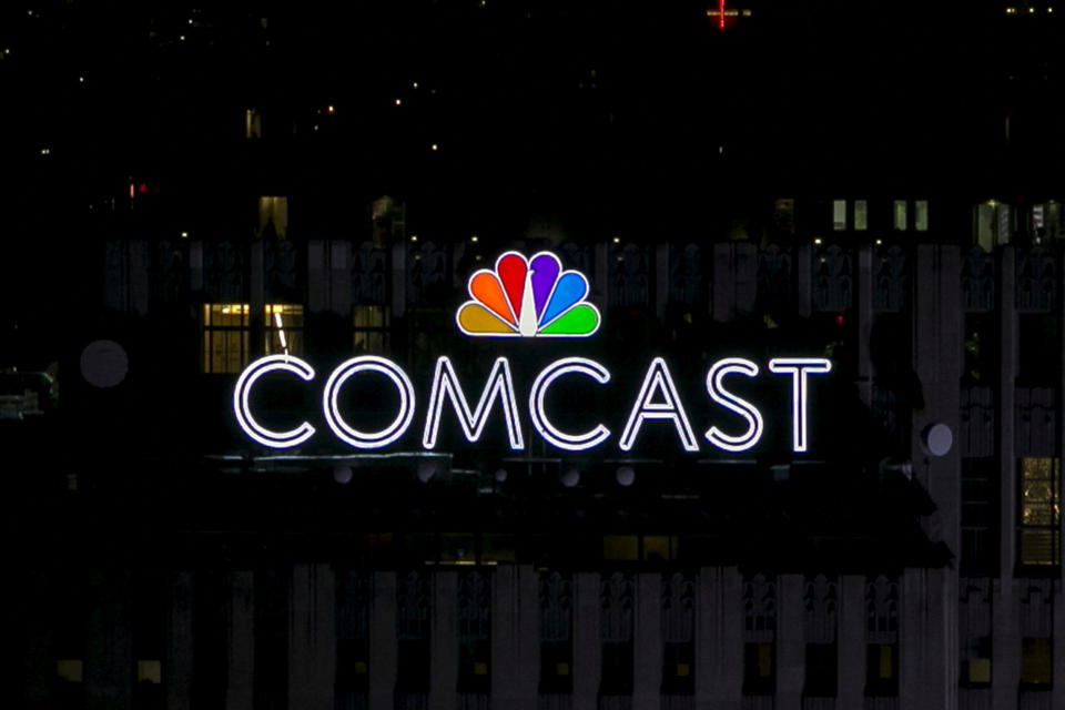 FILE PHOTO: The NBC and Comcast logo are displayed on top of 30 Rockefeller Plaza, formerly known as the GE building, in midtown Manhattan in New York July 1, 2015. The Art Deco skyscraper, also known as '30 Rock' and once displayed a large neon 'GE', unveiled the NBC Peacock logo and Comcast brand-name this week. REUTERS/Brendan McDermid/File Photo