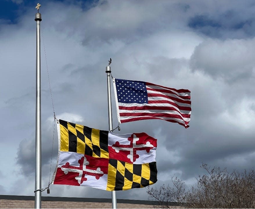 The Maryland flag, at half-staff, left, and American flag, at right, fly after President Joe Biden's remarks outside the Maryland Transportation Authority Police headquarters in Dundalk, Maryland on April 5, 2024.